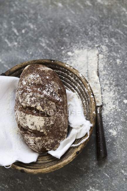 Волоський хліб в дерев'яному кошику з ножем — стокове фото