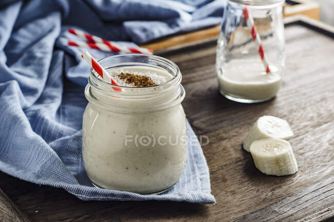 Frullato di banana con cannella, fiocchi di cocco e latte di cocco — Foto stock