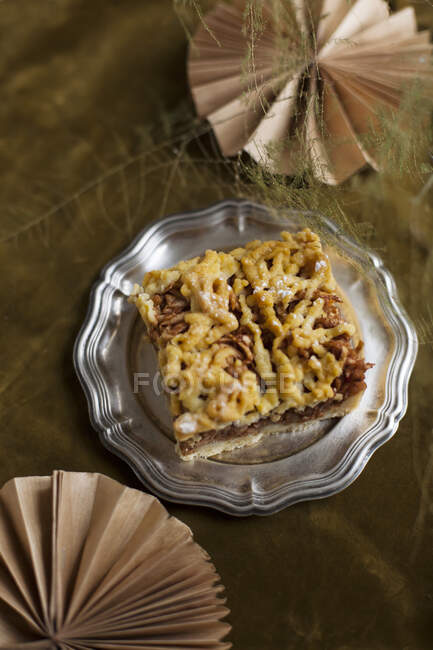 A slice of apple cake with streusel on a pewter plate — Stock Photo