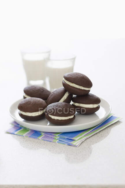 Whoopie cakes and two glasses of milk — Stock Photo