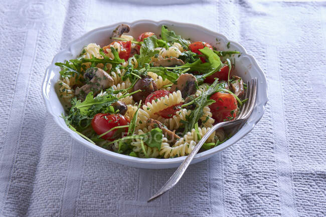 Fusilli with mushrooms, rocket and tomatoes — Stock Photo