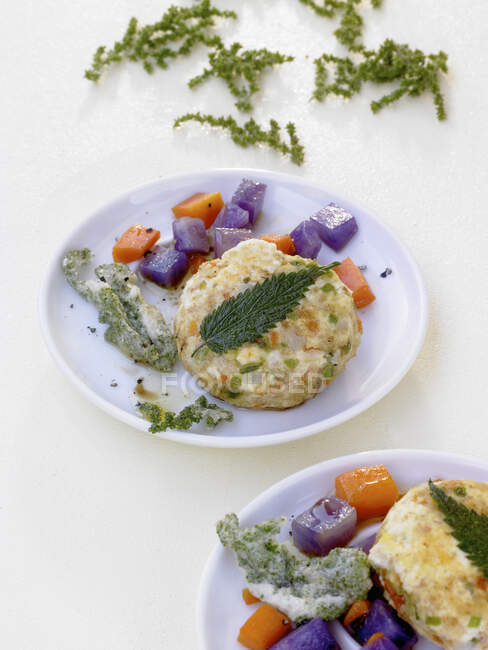 Stinging nettle and tofu fritters with mange tout, carrots and purple potatoes — Stock Photo