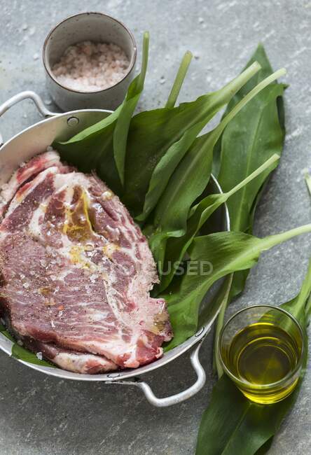 Trozos marinados de carne, ajo silvestre y aceite - foto de stock