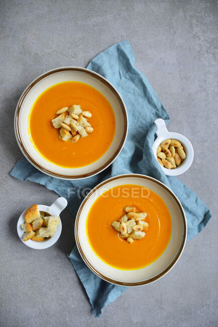 Pumpkin soup served with croutons and almonds — Stock Photo