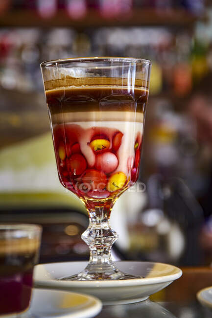 Una bebida de cacao con granos de chocolate servidos en un vaso de tallo decorativo - foto de stock