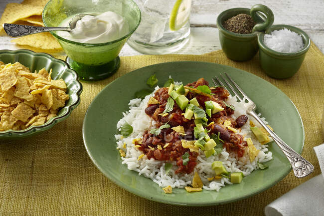Chilli con carne with avocado, rice and tortilla chips — Stock Photo