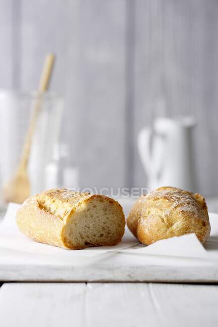 Two halves of a baguette on a white board — Stock Photo