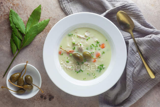 Bowl of chicken fricassee with peas, carrots and caperfruits — Stock Photo