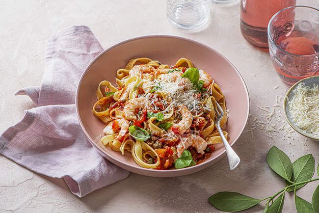 Pasta putanesca with tomato, anchovies, garlic sauce and garlic prawns — Photo de stock