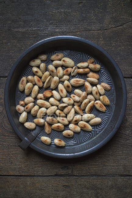 Toasted almonds in a round metal tray — Stock Photo