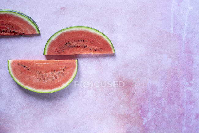 Fatias de melancia na superfície de pedra rosa — Fotografia de Stock