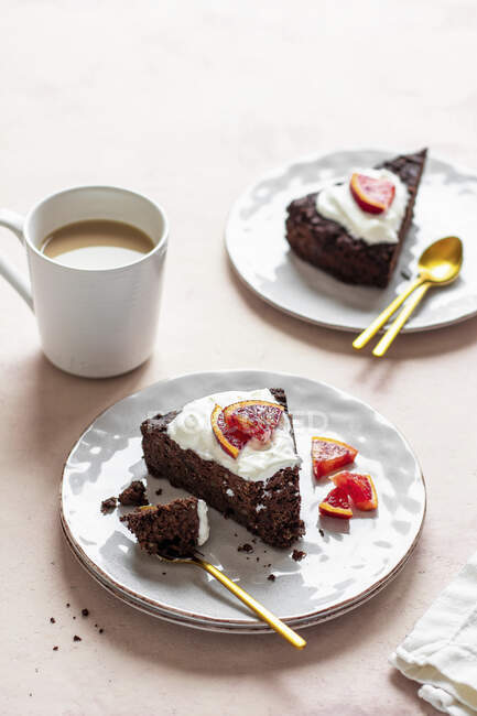 Pastel de chocolate con crema y café en plato blanco - foto de stock