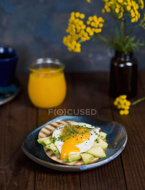 Bagel with avocado and liquid poached egg — Stock Photo