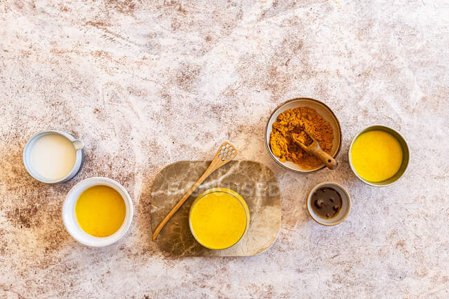 Selection of Golden Milks with Plant Milk, Syrup and Ground Turmeric — Stock Photo
