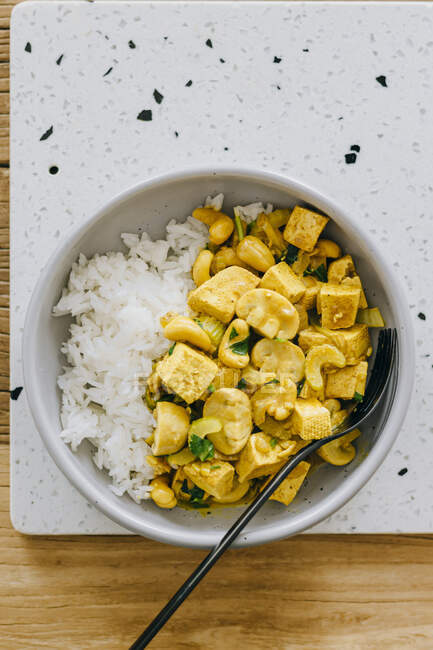Curry de tofu vegano con setas, anacardos y arroz - foto de stock