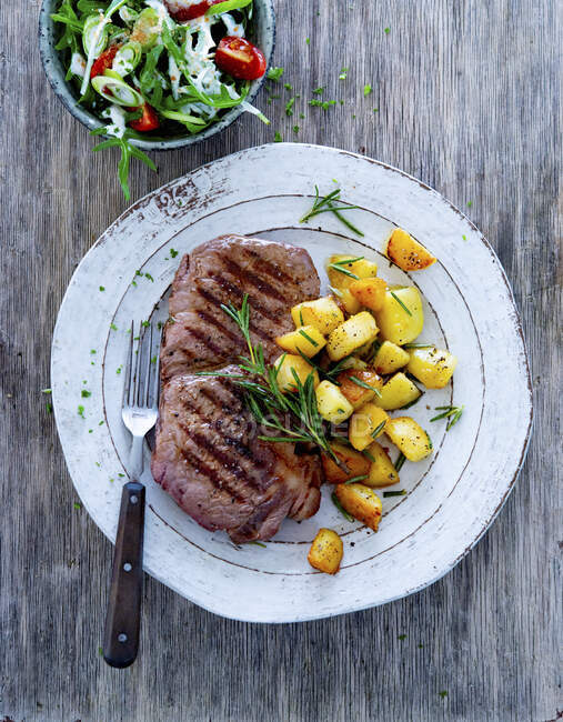 Steak croustillant avec pommes de terre au romarin et salade de jardin — Photo de stock