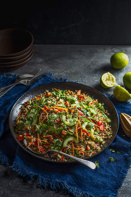 Vegan crunchy quinoa salad with carrot, peppers, coriander, limes, sesame seeds, sesame oil and penut butter dressing — Stock Photo