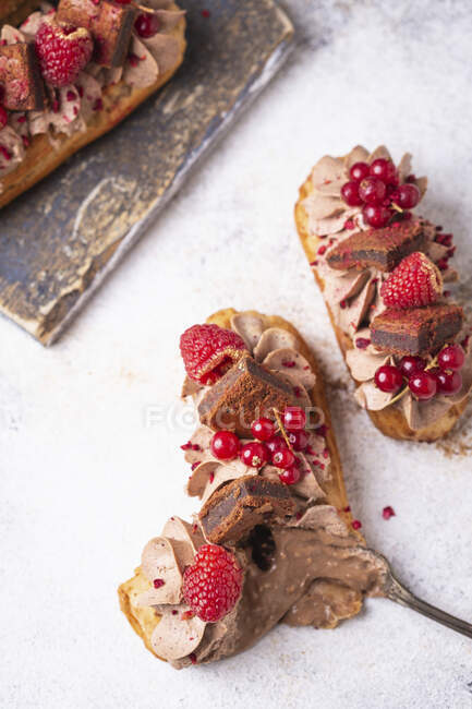 Eclairs with chocolate cream, brownie and berries — Stock Photo