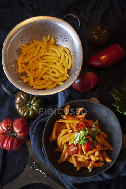 Pasta with sauce and spices on a dark table — Stock Photo