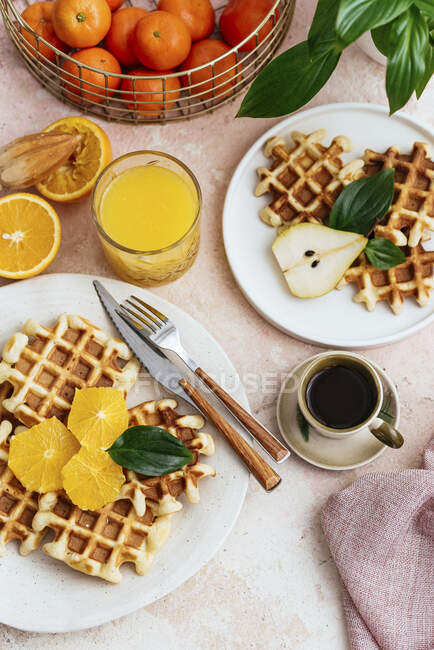 Homemade waffles with orange juice serving, top view — Stock Photo