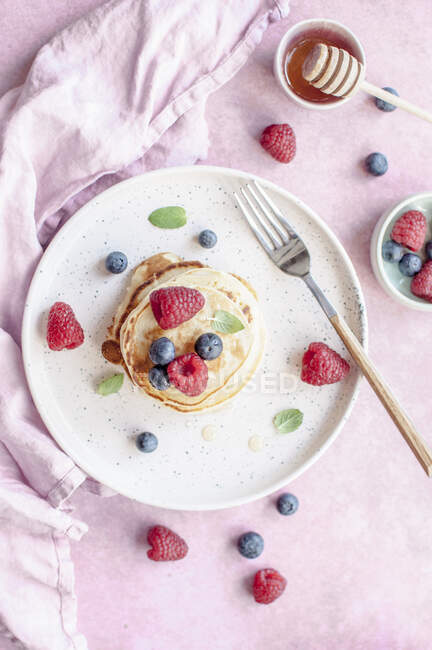Pancakes with honey and berries — Stock Photo