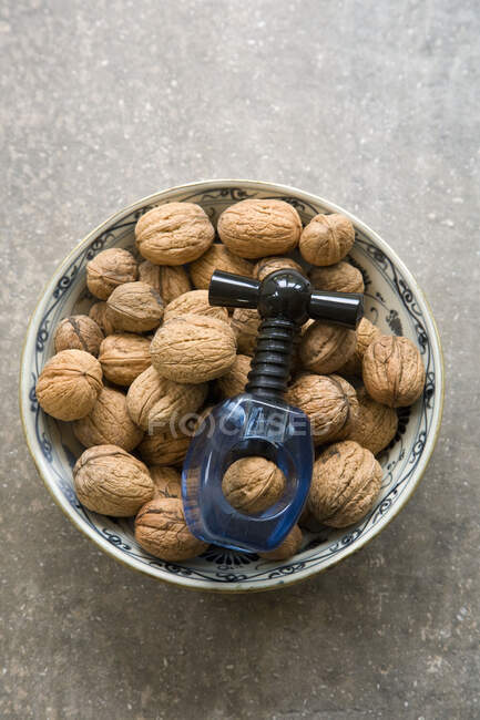 Bowl of walnuts with nut cracker — Stock Photo