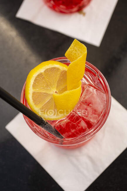 Campari cocktail with ice cubes and lemon slice — Stock Photo