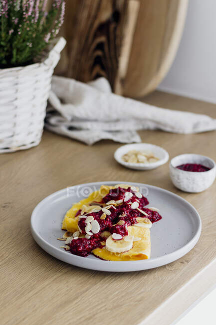 A sweet omelets with raspberries, bananas and almonds — Stock Photo