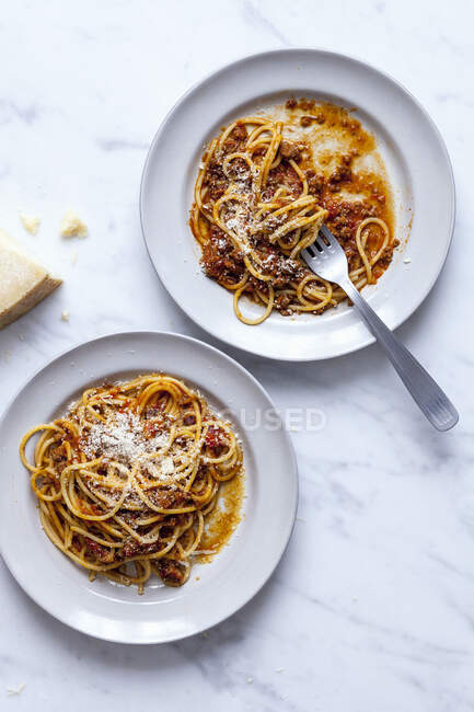 Спагетти болоньезе в двух белых тарелках — стоковое фото