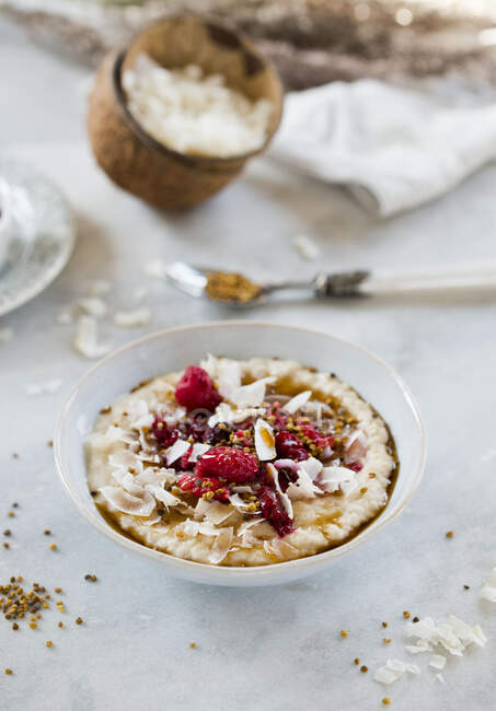 Coconut oatmeal with fresh raspberries, crumbs and almonds flakes — Stock Photo