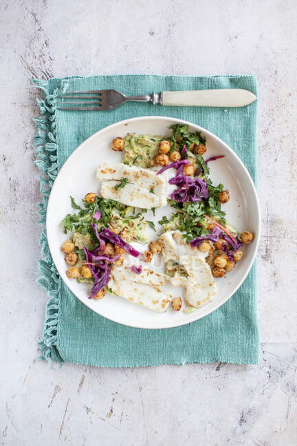 Courgettes cakes with spicy chickpeas, red cabbage, herbs and fried halloumi cheese — Stock Photo