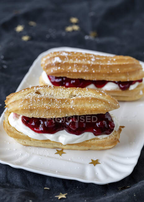 Eclairs with cranberries, closeup — Stock Photo