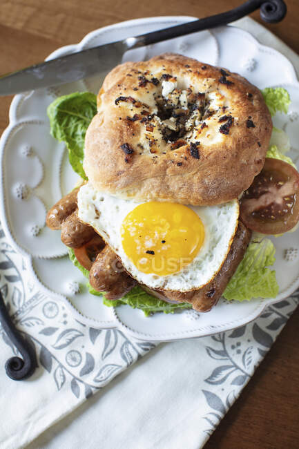 Bialys with Goat Cheese and Onions with an egg ans sausage — Stock Photo