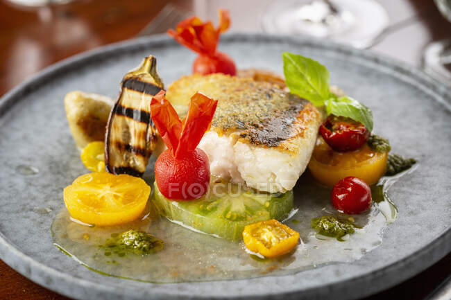 Gebratener Fisch mit gelben, grünen und roten Tomaten — Stockfoto