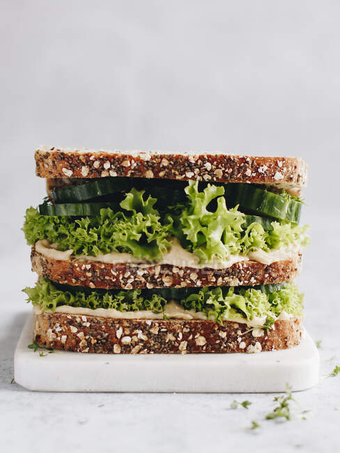 Wholegrain bread with hummus, lettuce, cucumber and cress — Stock Photo
