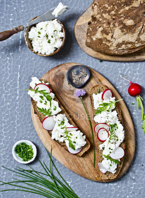 Sandwiches with cottage cheese and vegetables on wooden board — Stock Photo