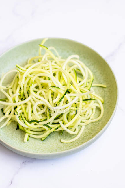 Spaghetti with spinach and green peas on white background — Stock Photo