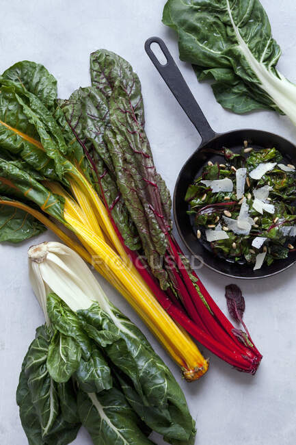 Top view of fresh green salad with herbs and vegetables on wooden background, flat lay — Stock Photo
