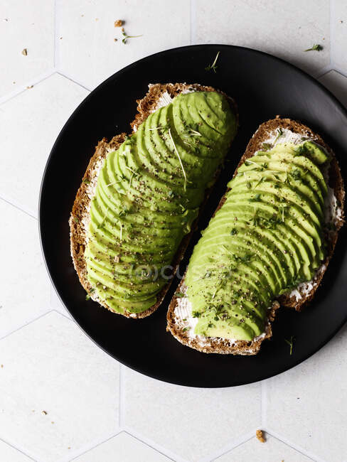 Sandwiches with cream cheese, avocado, pepper and cress — Stock Photo