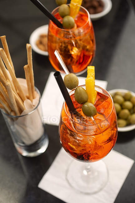 Aperitif with Aperol Spritz, olives and grissini — Stock Photo