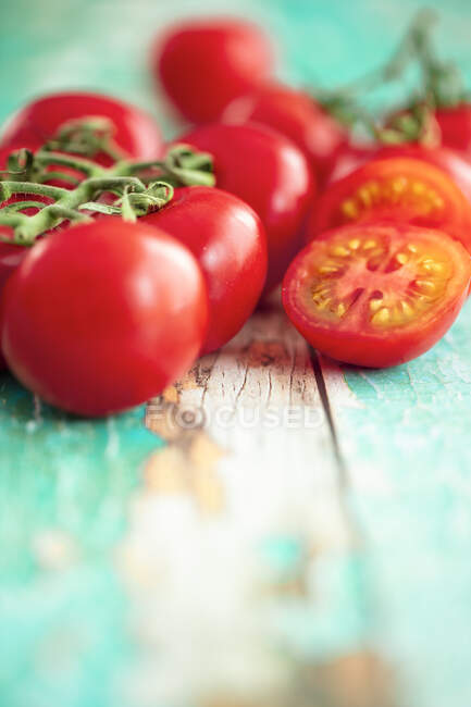 Vine tomatoes on a turquoise wooden background — Stock Photo