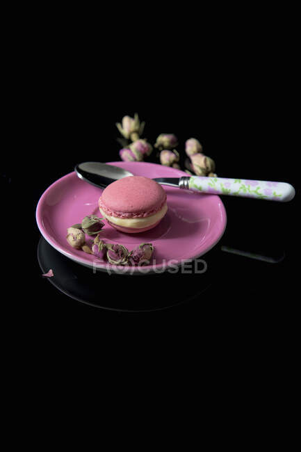 Macaron rosa com botões de rosa secos — Fotografia de Stock