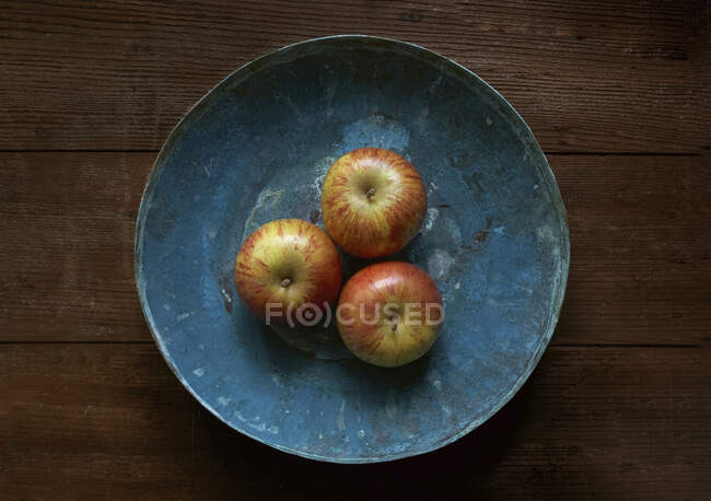 Manzanas en un bol de cobre azul - foto de stock