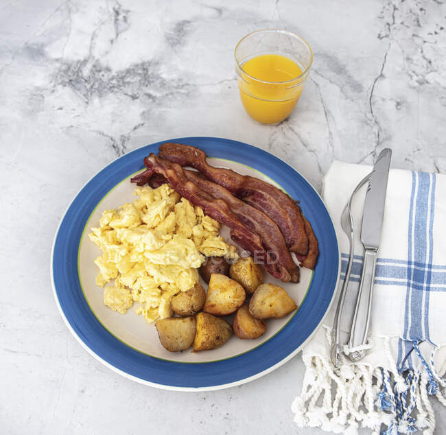 Bacon, potatoes and eggs for breakfast on plate — Stock Photo