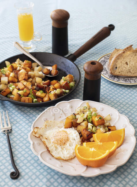 Roasted potatoes and sweet potatoes with egg — Stock Photo