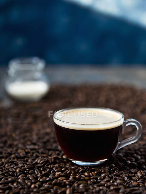 Taza de café en granos de café - foto de stock