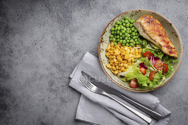 Випечені курячі груди з свіжим салатом, зеленим горохом і кукурудзою. — стокове фото