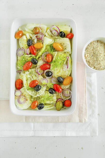 Padella di pomodorini finocchi, olive e cipolle rosse con pangrattato ed erbe aromatiche pronte per il forno — Foto stock