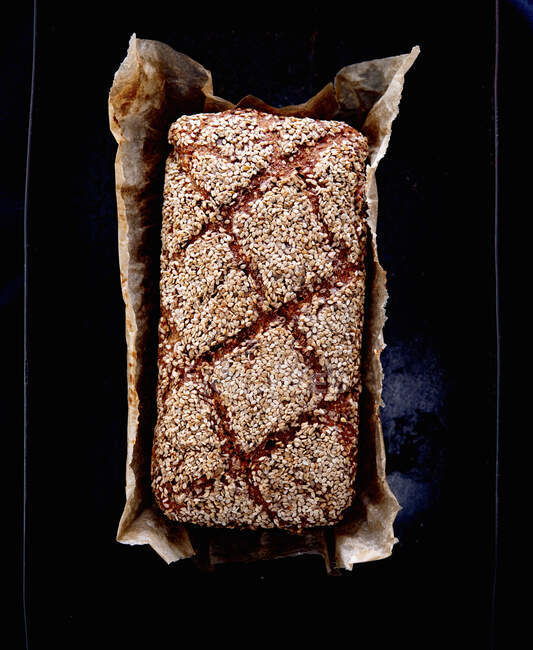 Wholemeal bread with sesame seeds in tin — Stock Photo