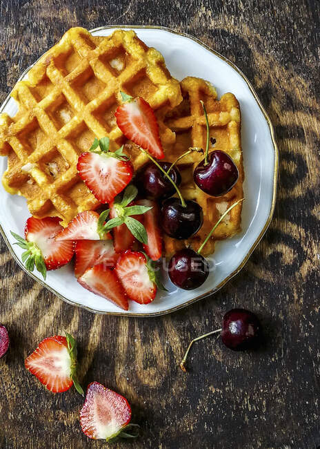 Waffles com cerejas e morangos, vista superior — Fotografia de Stock